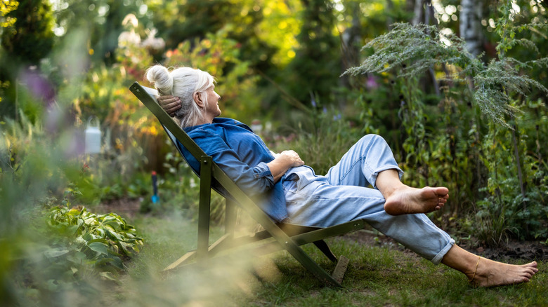 Woman relaxing in a lounge chair in her garden