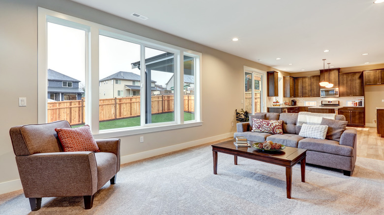 A light filled living room with large window looking out on a back yard.
