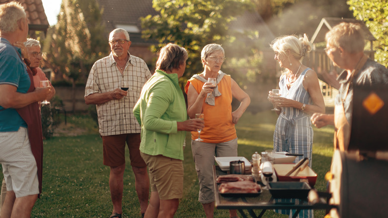 Friends and family standing outside at a backyard summer party