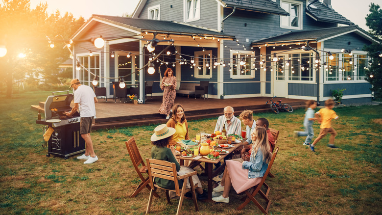 A large family is gathered together at a backyard July party