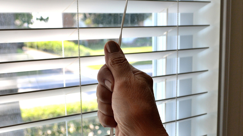 Someone pulling the cord on blinds.