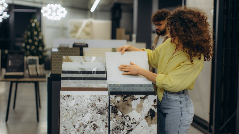 Woman carefully examining tile options.