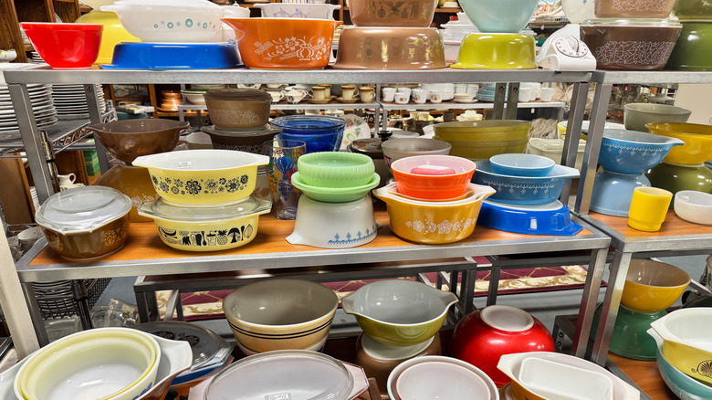 Various vintage Pyrex pieces on a thrift store shelf