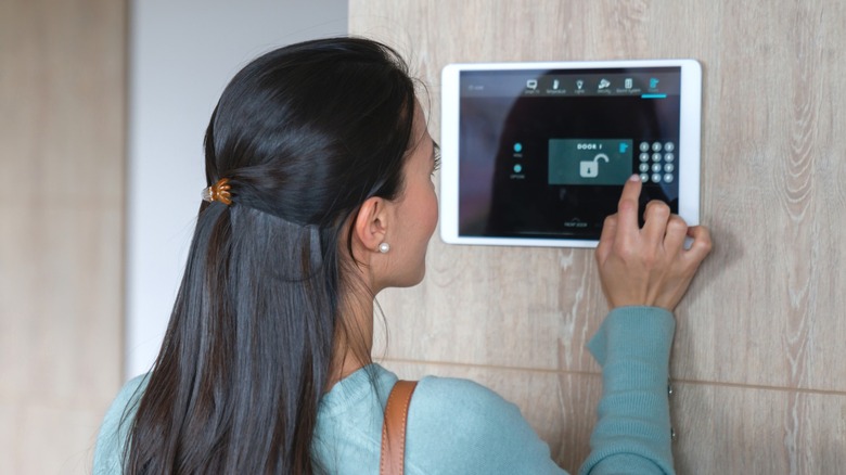 Woman disarming security system at smart home hub