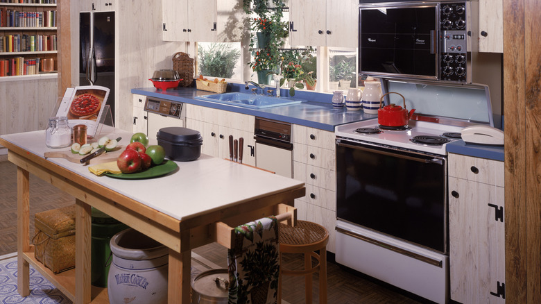 Homey and tidy 1980s kitchen with blue countertops and rustic kitchen island