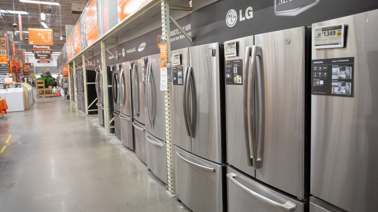 stainless steel fridges for sale in an aisle at a home improvement store