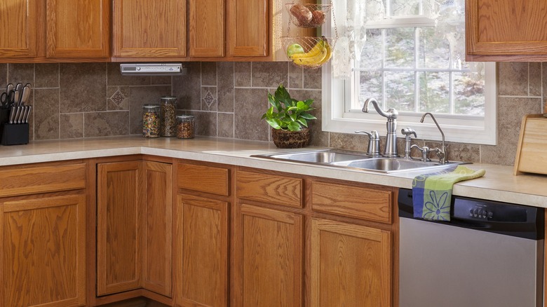 Kitchen with honey oak cabinets and gray/brown tile walls