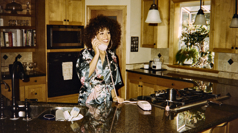 A woman on the phone in her kitchen in the 1980s