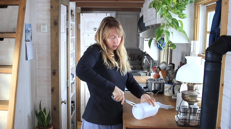 A woman cuts into a milk carton
