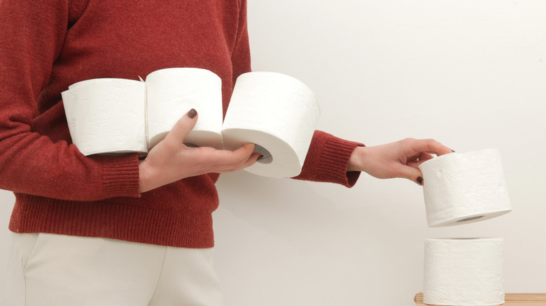 A person stacking toilet paper