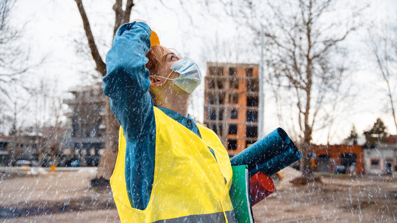 Construction worker looking at rain