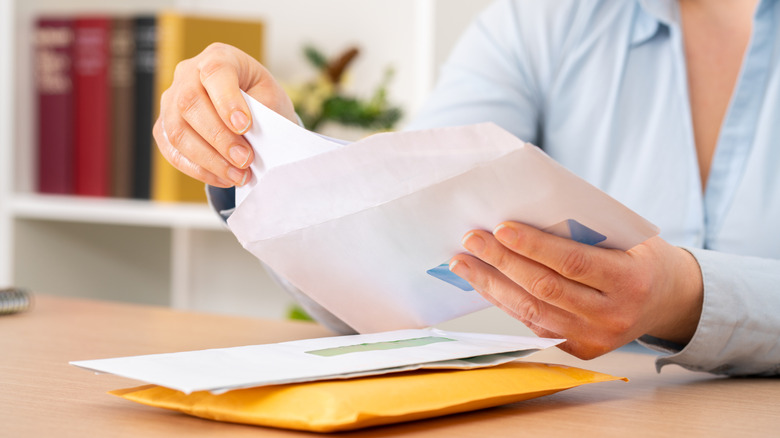 Close-up of a woman's hand sorting through mail and letters