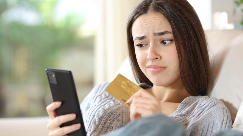 Woman showing some doubt about making an online purchase