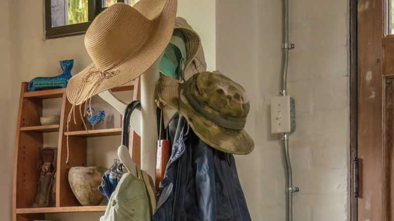 An overburdened hat and coat rack