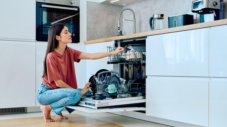A woman loading dirty dishes into a dishwasher
