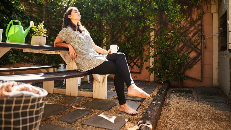 A woman sitting on a bench in her garden