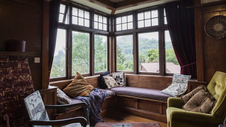 Cozy vintage living room with large windows.