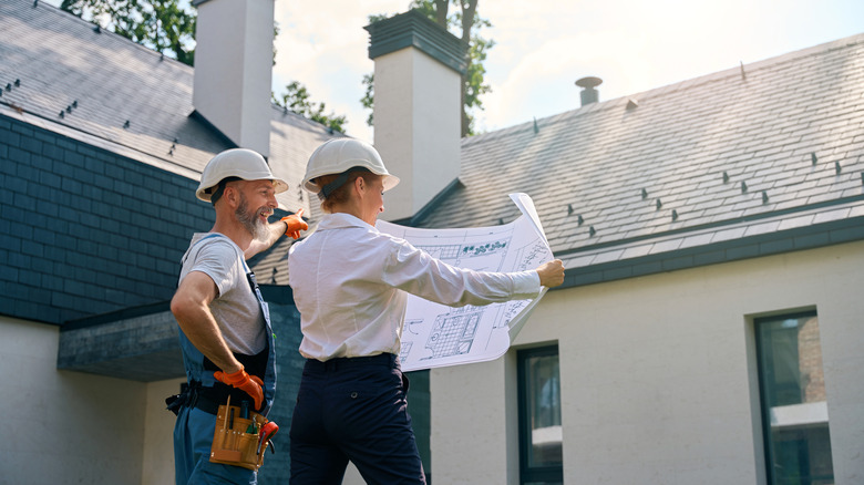 a contractor pointing at roof of a house