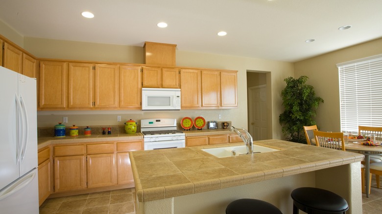 Kitchen with oak cabinets, tile floor and tan walls