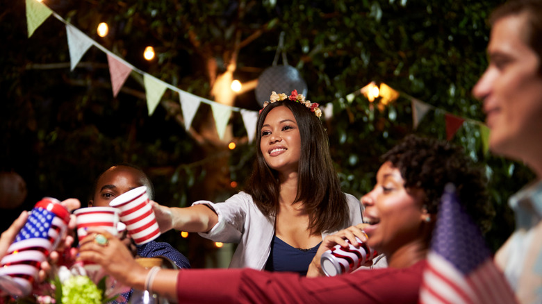 A group of friends having a 4th July party in backyard