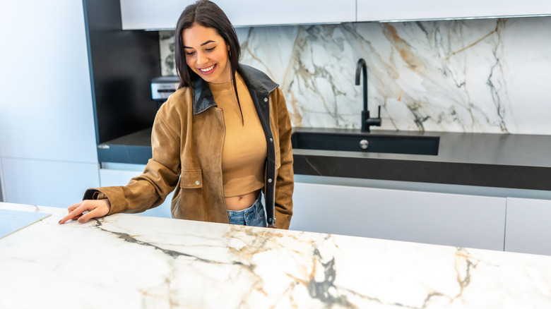 Woman admiring a kitchen countertop.
