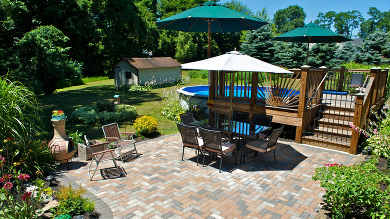 A patio and yard with a shed in the background