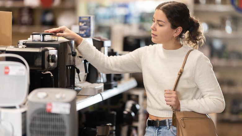Woman examining coffee makers in a store