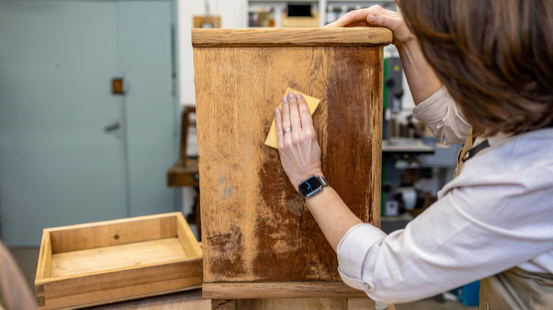 Woman restoring vintage cabinet
