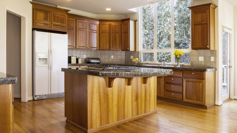 A large, dated kitchen with oak floors and cabinets