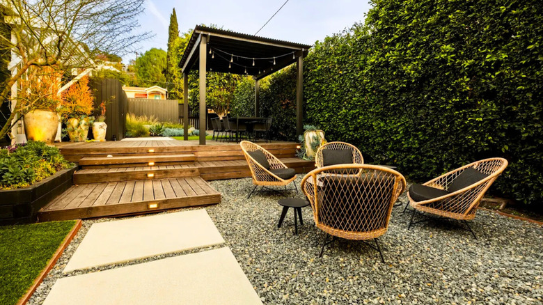 a Stylish Backyard Patio with Gravel, slabs, and Pergola
