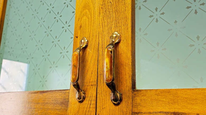 Old-fashioned door handles mounted to cabinet doors