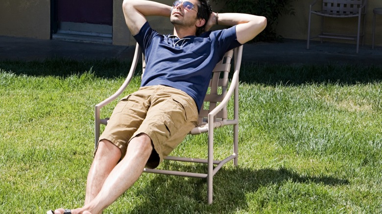 Man sitting in a chair out on the lawn enjoying the sun
