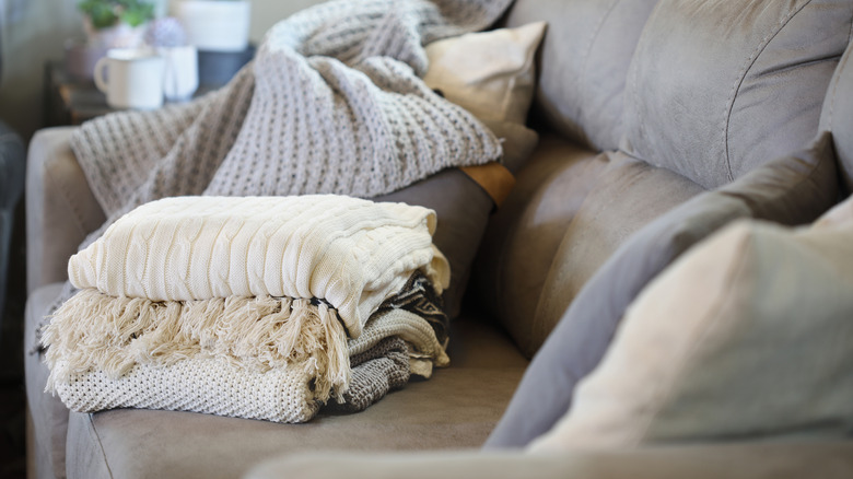Stack of throw blankets on couch