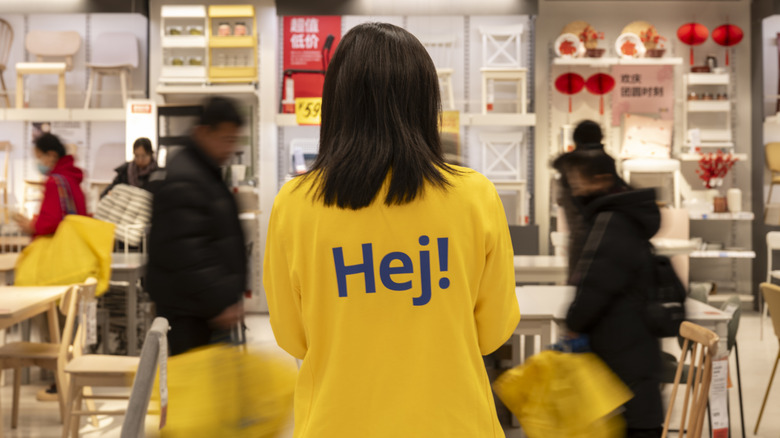 An IKEA employee and shoppers in the store