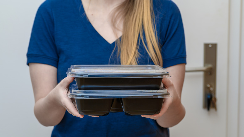 Person holding plastic food containers