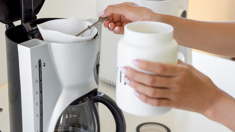 Person making coffee in a drip machine