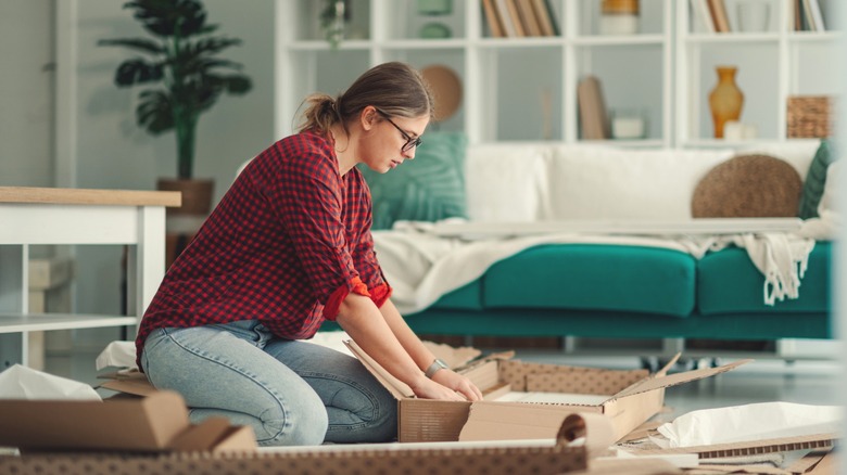 Person unboxing a new IKEA piece in a living room