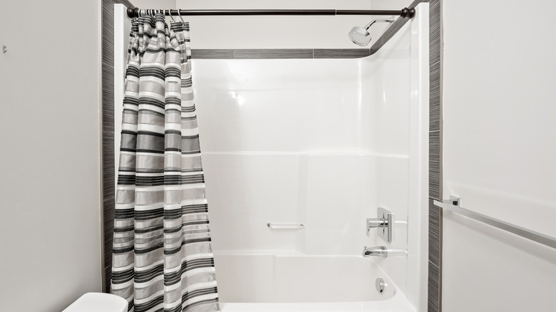 Shower with black and grey striped shower curtain