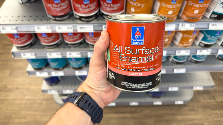 A person is shown holding a gallon of Sherwin Williams paint in front of in-store display shelves