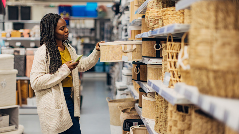 Woman looking at baskets on a store shelf.