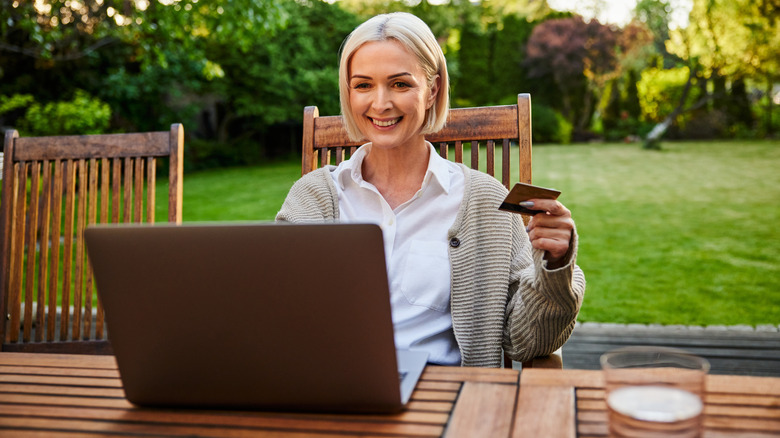 A person shopping online in their backyard