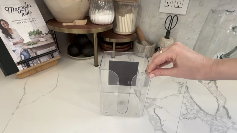 hand grabbing Dollar Tree dryer sheet holder