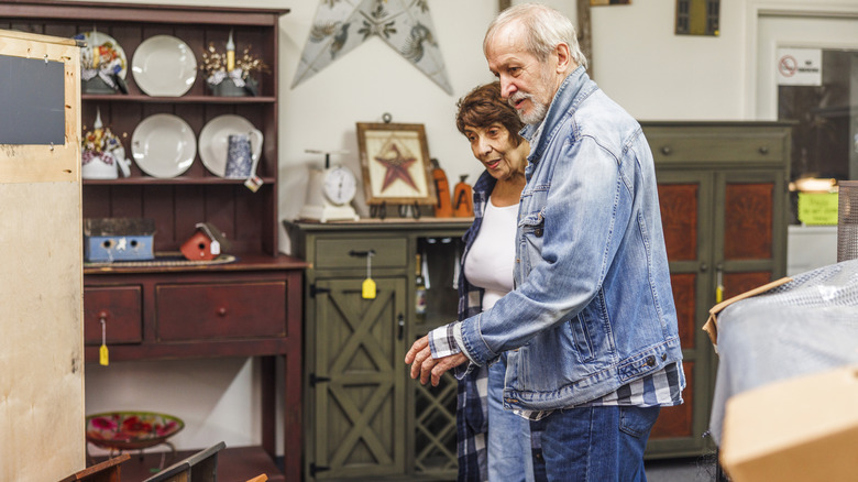 Two people looking at items in thrift store