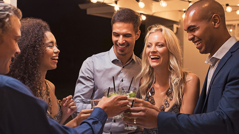 Group of friends cheersing at an elegant outdoor party.