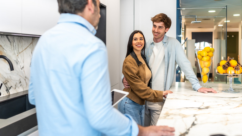 A couple discussing countertop alternatives in a design store.