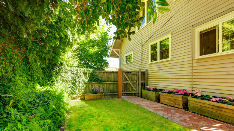 Small patio seating area on elevated outdoor deck with greenery
