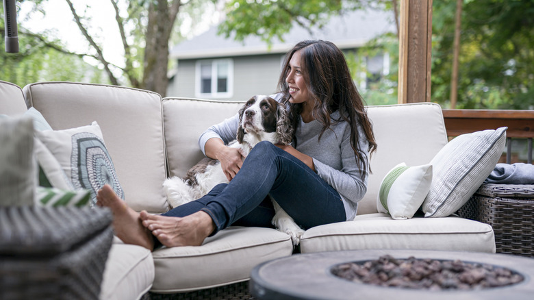 Woman and dog sitting on private patio