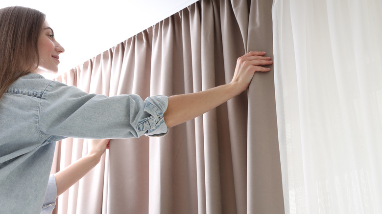 A woman hanging curtains