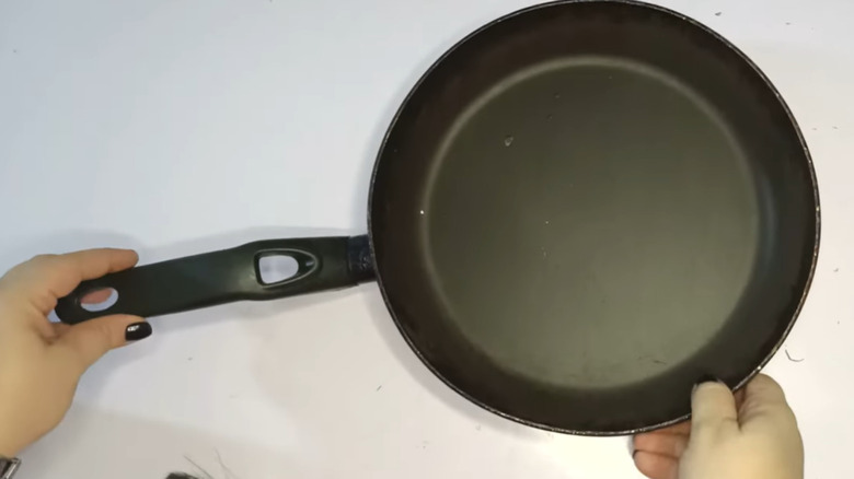 Someone holing a small frying pan.