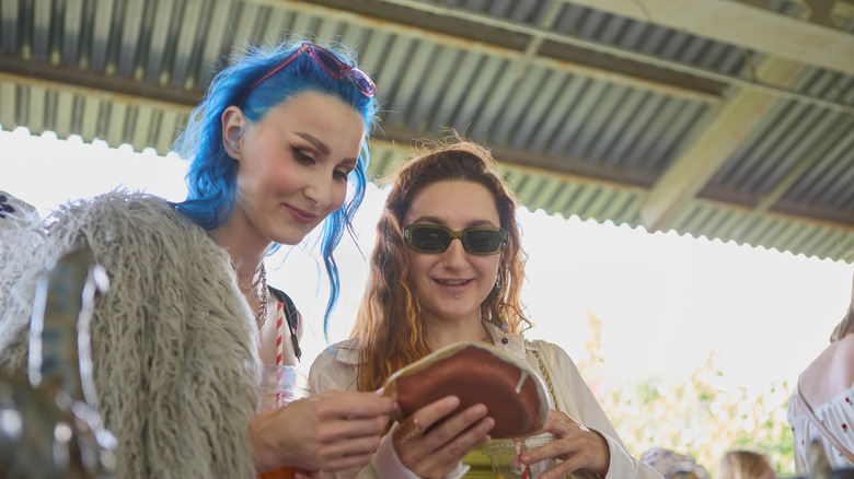 Two women look at vintage pottery